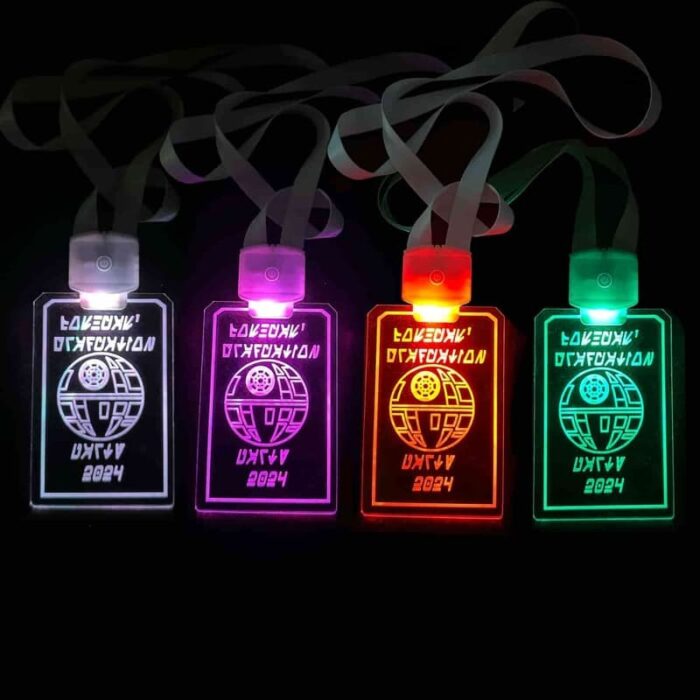 Four Star Wars themed custom engraved LED badges illuminating in white, pink, red and green