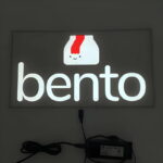 Bento box logo and text glowing brightly for el poster