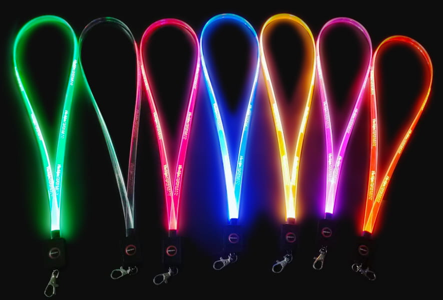 A collection of six glowing LED lanyards in assorted colors, radiating light