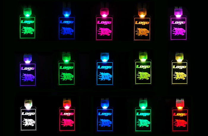Three rows of five acrylic LED badges with designs all lighting up a different rainbow color