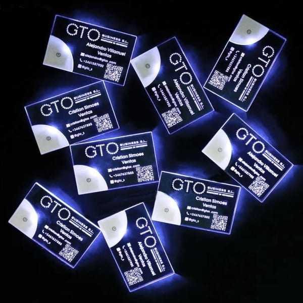 Many custom LED business cards glowing brightly on black background