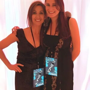 two young women at special event wearing lanyard and hanging light up panel with "Sophie 13" lighting up like a VIP badge