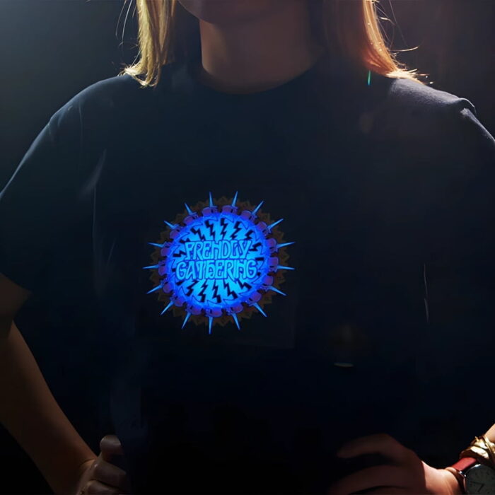 Close up of woman with two hands on hips showing customized LED shirt design with Frendly Gathering logo lighting up brightly on chest