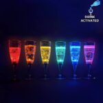 Line up of 6 drink activated LED champagne flutes each lighting up a different rainbow color