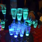 LED champagne glass tower with glasses stacked up glowing bright blue and green