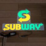 Subway logo lighting up on ground on EL poster