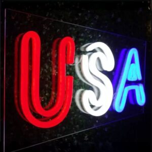 Side angle of clear acrylic LED neon sign with USA letters lighting up red white and blue