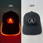 Side-by-side display of two hats; one features a lit logo, while the other shows the logo without illumination