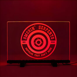 Red illuminated acrylic sign reading "Smokin' Serpents" displayed on a stand.