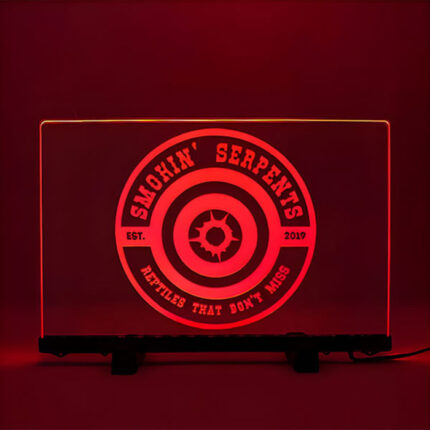 Red illuminated acrylic sign reading "Smokin' Serpents" displayed on a stand.