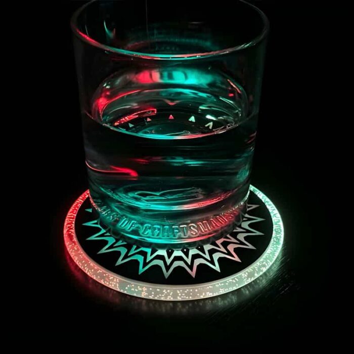A cocktail glass with liquid lighting up from the color changing coaster