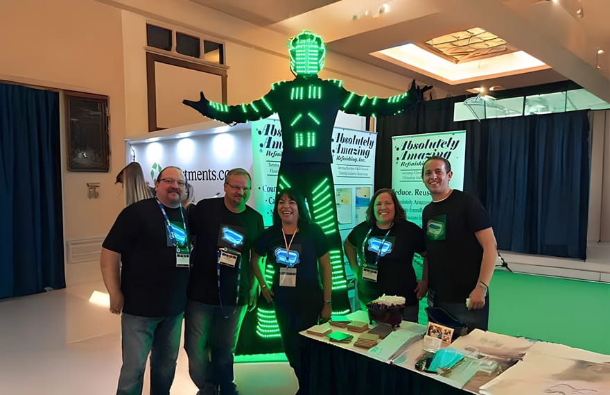 Group of five people wearing custom LED shirts standing with man in full LED Tron suit