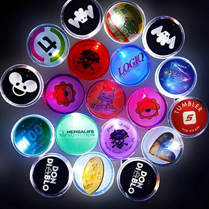 About 20 different LED pin designs in a dark room all lighting up with customized logos and artwork