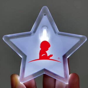 St Jude Logo printed onto star shaped LED pin lighting up in someone's hand