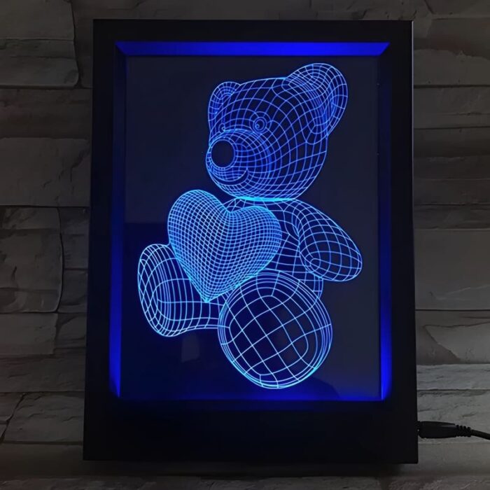A 3D printed teddy bear with a heart, illuminated within a picture frame, showcasing its charming design.
