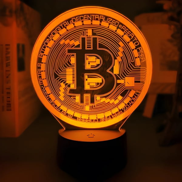bitcoin logo laser engraved onto LED table lamp glowing bright orange
