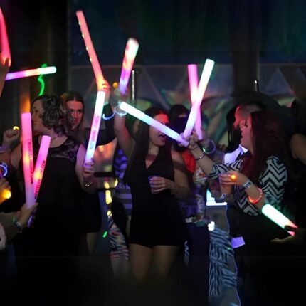 Big group of people at special event dancing with LED foam sticks
