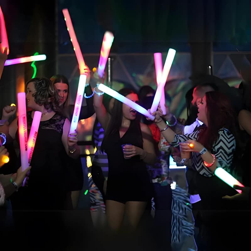 Big group of people at special event dancing with LED foam sticks