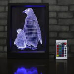 A black-framed LED sign featuring a 3D engraved penguin
