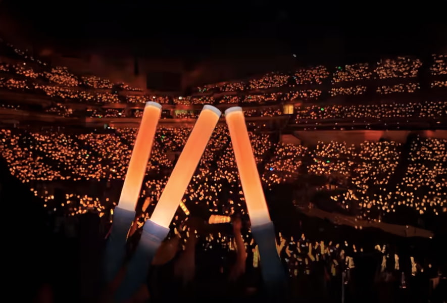 EXO-L fans at the Japan Dome concert wave remote-controlled wands in a vibrant crowd
