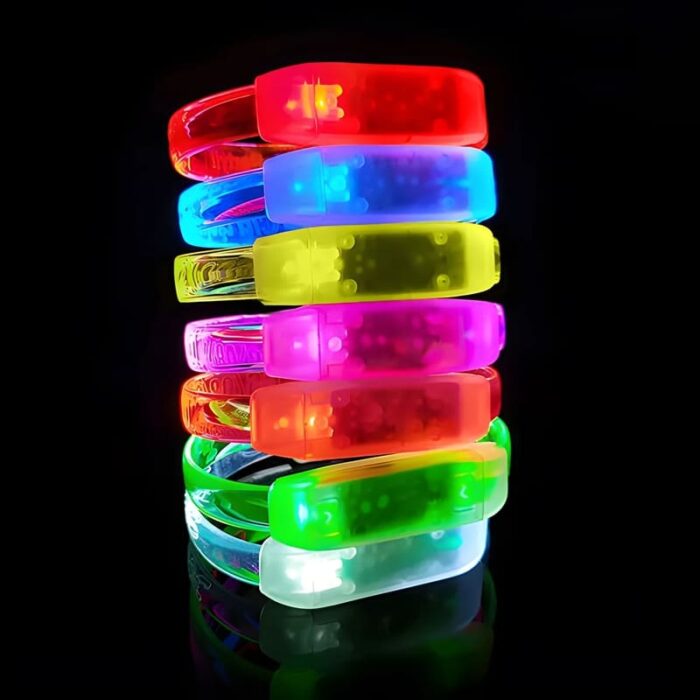 All 7 color LED bracelets stacked in a row shining bright red, blue, yellow, pink, orange, green and white