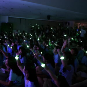 Crowd at event waving green LED bracelets in air