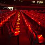 Large venue with red colored led bright batons in the seats