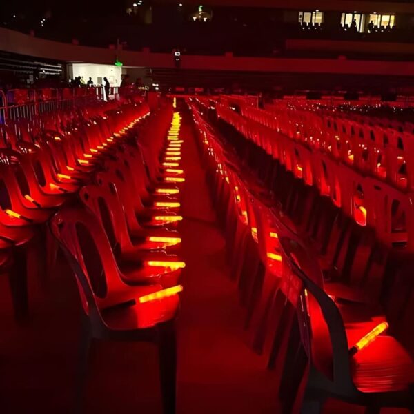 Large venue with red colored led bright batons in the seats