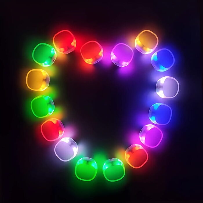 Aerial shot of silicone led bracelets lined up in the shape of a heart lighting up a different array of glowing colors