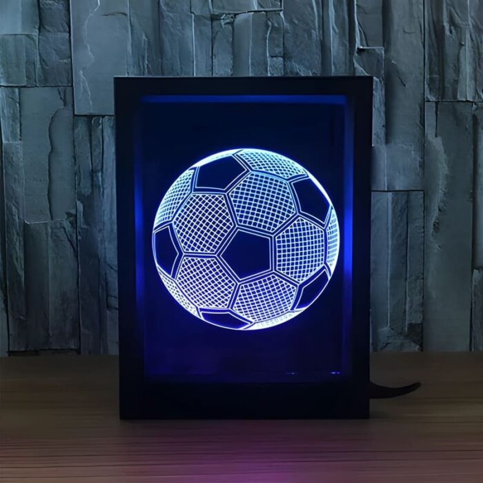 A 3D engraved soccer ball in a black frame illuminated by a blue LED light, showcasing a unique sports gift