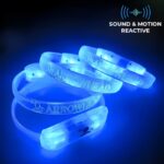 4 sound and motion reactive LED bracelets glowing bright blue on table with custom design "Arrowhead" laser engraved onto them
