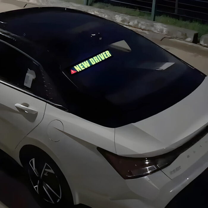 glowing new driver safety battery powered sticker lighting up on back windshield of car