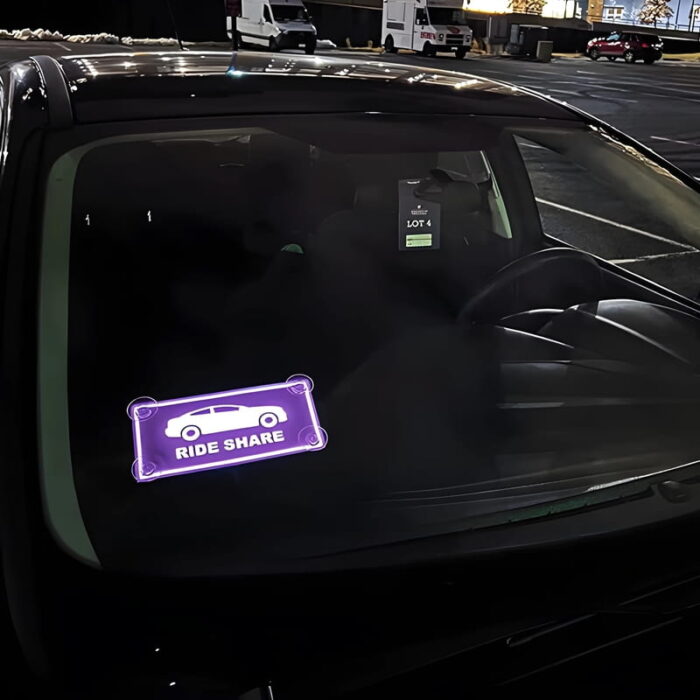ride share glowing logo el car sticker lighting up on front windshield of car