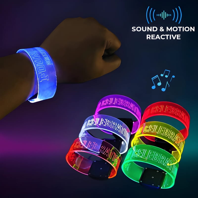 Closeup of wrist wearing engraved LED wristband glowing blue next to 6 other LED wristbands all glowing in different colors