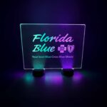 A custom engraved led table sign for Florida Blue Cross Blue Shield event glowing in green and purple neon glow