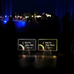 Two glowing light up acrylic table cards at a wedding