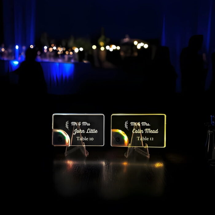Two glowing light up acrylic table cards at a wedding