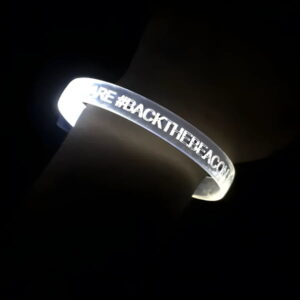 close up of led bracelet on wrist with the phrase #BackTheBeacon glowing bright white