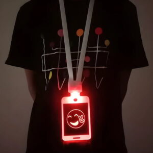 Close up of person wearing LED badge around neck that is glowing bright red with a smiley face logo