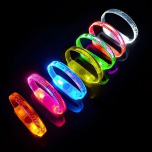 8 LED bracelet color options lined up on table with custom engraved messages