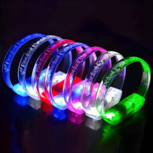 Rocket Everything custom LED bracelets lined up on table glowing blue, red, white, pink and green