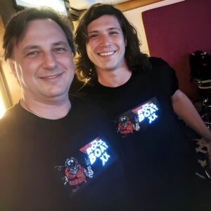 A father and son wearing light up t-shirts featuring "Deadpool" with lights, enjoying the Rock Boat event