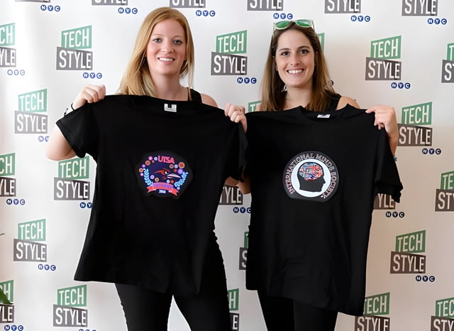 Two women founders of Flashion Statement holding up light up t-shirts