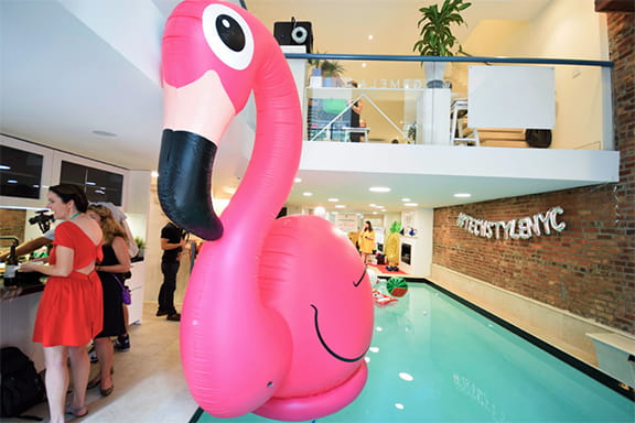 A vibrant pink flamingo inflatable is positioned in the middle of a sparkling pool, creating a fun summer vib