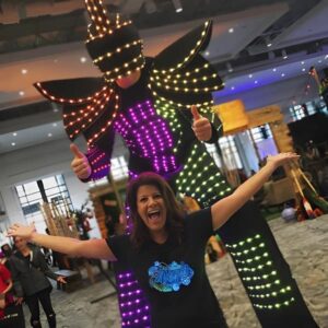 Woman posing at trade show convention center in front of LED robot while wearing her own custom light up shirt