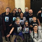 A group of dancers wearing illuminated lighted t-shirts posing for the camera