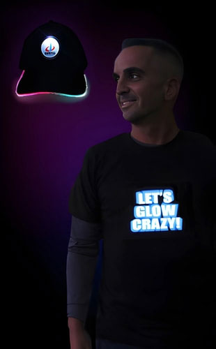 A man showcases a light up shirt that reads "Let's Glow Crazy" and an LED hat with a personalized logo